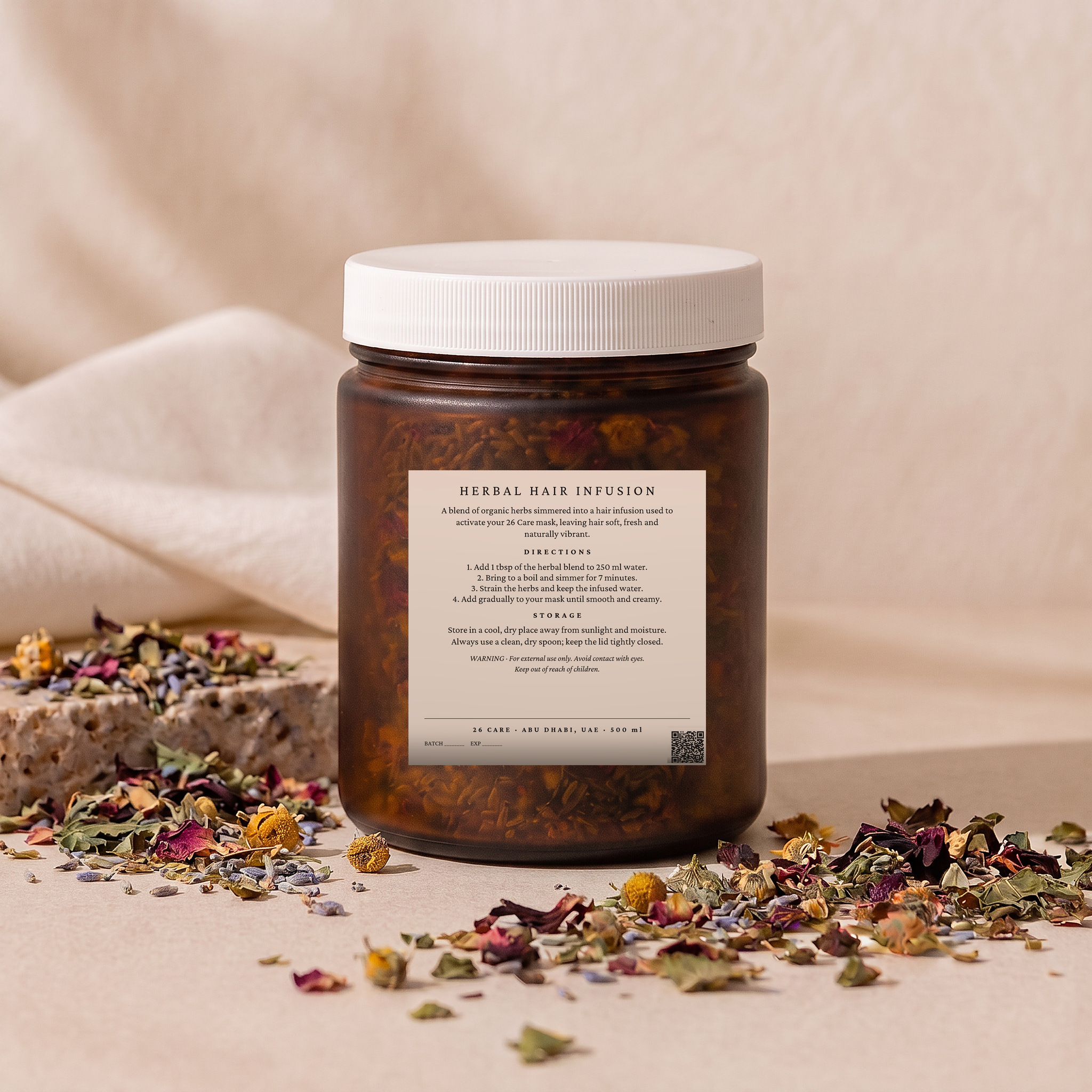 26 Care Herbal Hair Infusion in a frosted amber jar with loose dried botanicals beside it — Back — directions & warnings